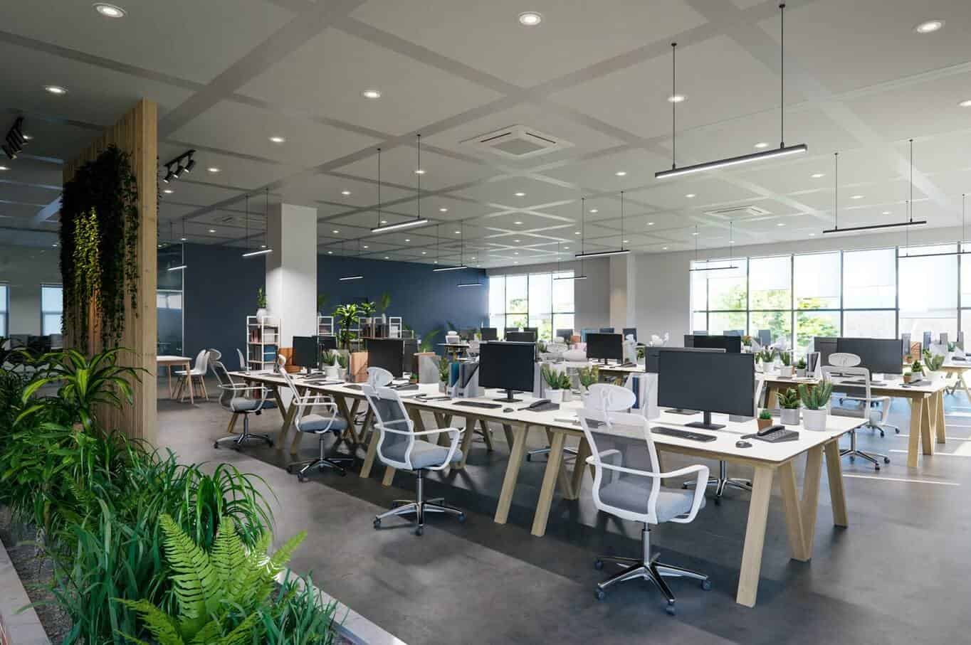 Modern open-plan office with wooden desks, white ergonomic chairs, and lush green indoor plants.